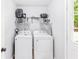 Bright laundry room featuring a modern washer, dryer, and overhead storage at 37 Winesap Ct, Temple, GA 30179