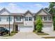 Charming townhome featuring a two-car garage, neutral siding, and well-manicured landscaping at 5584 Cannonade Ln, Stonecrest, GA 30058