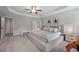 Large main bedroom featuring a tray ceiling, neutral paint, and a doorway to the en-suite bathroom at 5584 Cannonade Ln, Stonecrest, GA 30058