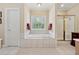 Relaxing bathroom featuring a soaking tub with tile surround and separate shower at 6125 Fouts Mill Rd, Douglasville, GA 30135