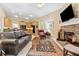 Cozy living room features a stone fireplace, TV, leather sofa, and an open layout to the kitchen at 6125 Fouts Mill Rd, Douglasville, GA 30135