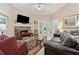 Bright living room with stone fireplace, tv, leather couch and sunroom access at 6125 Fouts Mill Rd, Douglasville, GA 30135