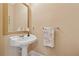 Elegant powder room with pedestal sink, gold-framed mirror, and floral accents at 6125 Fouts Mill Rd, Douglasville, GA 30135