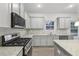 Modern kitchen with stainless steel appliances, ample counter space, and gray shaker cabinets at 1462 Stephens View Dr, Loganville, GA 30052