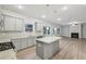 Modern kitchen with granite countertops, gray cabinets, stainless steel appliances, and open access to living room at 1462 Stephens View Dr, Loganville, GA 30052