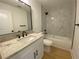 Bathroom features white vanity with granite countertop, and a shower/tub with marble-style tiles at 2167 Main Nw St, Atlanta, GA 30318