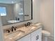 Modern bathroom featuring double sinks, granite counters, black fixtures, and separate soaking tub with marble surround at 2167 Main Nw St, Atlanta, GA 30318