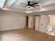 Spacious bedroom with tray ceiling, fan, and wood floors, leading into the bathroom through a sliding barn door at 2167 Main Nw St, Atlanta, GA 30318