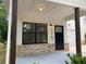 Inviting front porch features dark wood columns, brick accents, and a stylish front door at 2167 Main Nw St, Atlanta, GA 30318