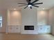 Open-concept living room with tray ceiling, fan, fireplace, wood floors, and custom cabinets for storage at 2167 Main Nw St, Atlanta, GA 30318