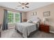 This bedroom has a cozy feel, provided by soft textures, soothing colors, and an inviting light from a window at 6355 Stallion Dr, Cumming, GA 30040