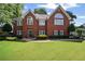 Charming brick home with a manicured lawn and beautiful landscaping at 6355 Stallion Dr, Cumming, GA 30040