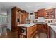 Warm kitchen with custom wood cabinets, marble island, and hardwood flooring at 6355 Stallion Dr, Cumming, GA 30040