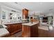 Bright kitchen with hardwood cabinets, a marble top island, and an adjacent dining and living area at 6355 Stallion Dr, Cumming, GA 30040