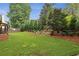 Large backyard with lush lawn, mature trees, and manicured landscaping at 6720 Wolford Ct, Johns Creek, GA 30097
