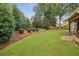 Beautiful backyard with mature trees, manicured lawn, and landscaping at 6720 Wolford Ct, Johns Creek, GA 30097