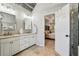 Well-lit bathroom with a double vanity, decorative mirrors, and travertine tile flooring at 6720 Wolford Ct, Johns Creek, GA 30097