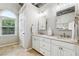 Bright bathroom features a double vanity with white cabinets and a large window at 6720 Wolford Ct, Johns Creek, GA 30097