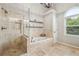 Bathroom featuring a soaking tub, glass enclosed shower, and arched window at 6720 Wolford Ct, Johns Creek, GA 30097