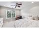 Sun-filled bedroom features neutral carpet, a ceiling fan, and a large window at 6720 Wolford Ct, Johns Creek, GA 30097
