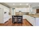 Bright kitchen with white cabinets, stainless appliances, stone countertops, and island with seating at 6720 Wolford Ct, Johns Creek, GA 30097