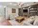 Comfortable living room features a fireplace, built-in shelving, ceiling fan and wood floors at 6720 Wolford Ct, Johns Creek, GA 30097