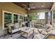 Inviting covered stone patio with ceiling fan, television and stone fire pit at 6720 Wolford Ct, Johns Creek, GA 30097