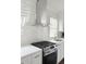 Bright kitchen featuring a modern gas stove, stylish vent hood, and white tiled backsplash at 1740 Langston Sw Ave, Atlanta, GA 30310