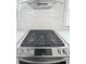 Close-up of stainless steel gas stove with modern vent hood and white tile backsplash at 1740 Langston Sw Ave, Atlanta, GA 30310