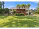 Spacious backyard featuring a well-maintained lawn, mature trees, and a welcoming porch perfect for outdoor relaxation at 3527 Starwood Sw Trl, Lilburn, GA 30047
