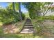 Landscaped backyard featuring stone steps leading up a gentle hill, providing a scenic pathway through the lush greenery at 3527 Starwood Sw Trl, Lilburn, GA 30047