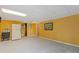 Finished basement rec room space with yellow paint, tile ceiling, and access to the exterior at 3527 Starwood Sw Trl, Lilburn, GA 30047