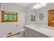 Well-lit bathroom with a granite countertop vanity, white cabinets, and framed window at 3527 Starwood Sw Trl, Lilburn, GA 30047