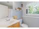 Neutral toned bathroom featuring a wood vanity and a window with natural light at 3527 Starwood Sw Trl, Lilburn, GA 30047
