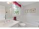 Bright bathroom with a white tiled bath and framed botanical prints on the wall at 3527 Starwood Sw Trl, Lilburn, GA 30047