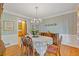 Elegant dining room with hardwood floors, decorative wallpaper, and chandelier lighting at 3527 Starwood Sw Trl, Lilburn, GA 30047