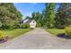 Long paved driveway leads to a home with a two-car garage and manicured landscaping at 3527 Starwood Sw Trl, Lilburn, GA 30047