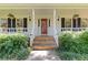 Charming front entrance with a red door, manicured bushes, and hanging potted plants at 3527 Starwood Sw Trl, Lilburn, GA 30047