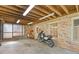 Garage showcasing a motorcycle parked inside with concrete floor, brick walls, and ample lighting at 3527 Starwood Sw Trl, Lilburn, GA 30047