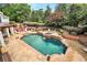 Backyard oasis featuring a pool, spa, patio, and beautifully landscaped garden with mature trees at 5045 Harrington Rd, Johns Creek, GA 30022