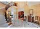 Elegant foyer features a curved staircase, patterned wallpaper, and a view into the home's library at 5045 Harrington Rd, Johns Creek, GA 30022