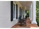 Covered porch with rocking chairs and brick flooring, creating a charming and inviting outdoor space at 5045 Harrington Rd, Johns Creek, GA 30022