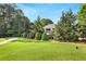 Expansive backyard with lush lawn and neatly trimmed trees surrounding the home at 5045 Harrington Rd, Johns Creek, GA 30022
