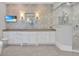 This bathroom features dual vanities, decorative wallpaper, a shower stall, and a wall-mounted television at 5045 Harrington Rd, Johns Creek, GA 30022