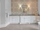 Bathroom featuring dual vanities, stylish wallpaper, decorative mirrors, and elegant lighting fixtures at 5045 Harrington Rd, Johns Creek, GA 30022