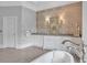 This bathroom offers white cabinetry, stylish wallpaper, and a sleek soaking tub with modern fixtures at 5045 Harrington Rd, Johns Creek, GA 30022