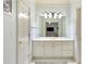 Bright white bathroom featuring a large mirror and vanity with storage at 5045 Harrington Rd, Johns Creek, GA 30022