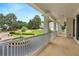 Expansive front porch featuring white columns and railing, offering a view of the lush, landscaped front yard at 5045 Harrington Rd, Johns Creek, GA 30022