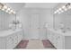 Bathroom featuring double sinks with white cabinetry, tiled flooring and two mirrors at 5045 Harrington Rd, Johns Creek, GA 30022