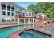 Gorgeous pool area with a spa, lounge chairs, manicured greenery, and the home's elegant exterior at 5045 Harrington Rd, Johns Creek, GA 30022